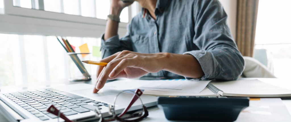 Marketing professional using a laptop to answer emails and sales calls.