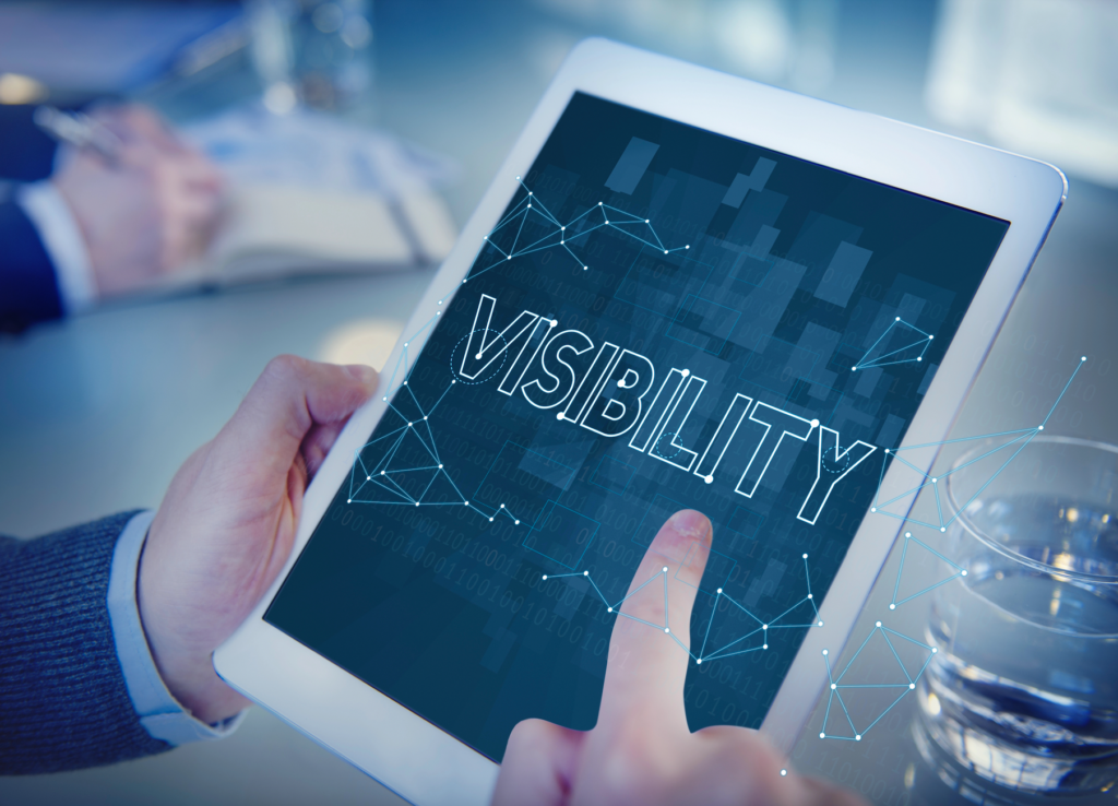 A marketing professional holding an iPad with a graphic that says visibility.